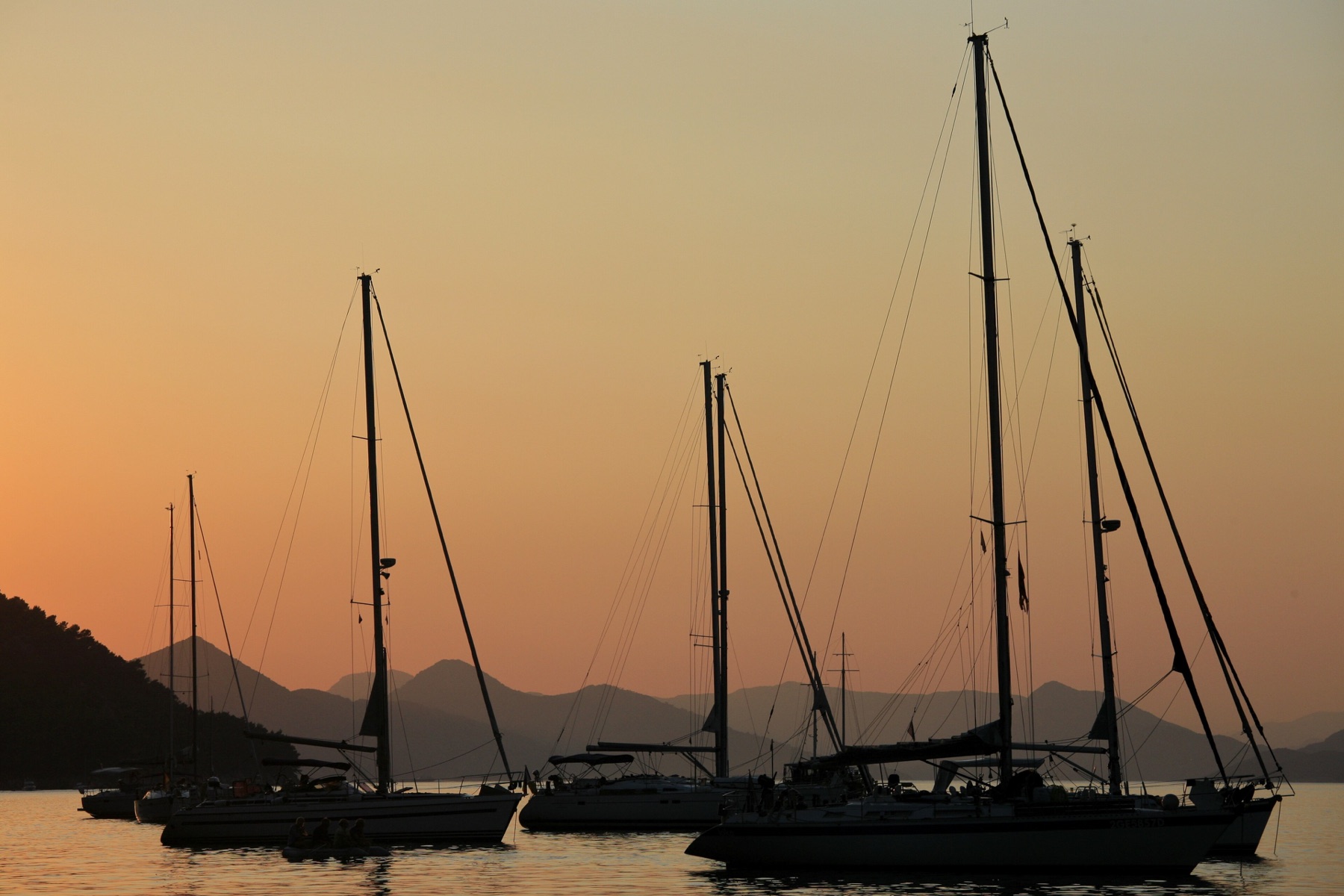 Segelyachten als Silhouetten im Sonnenuntergang vor Kroatien